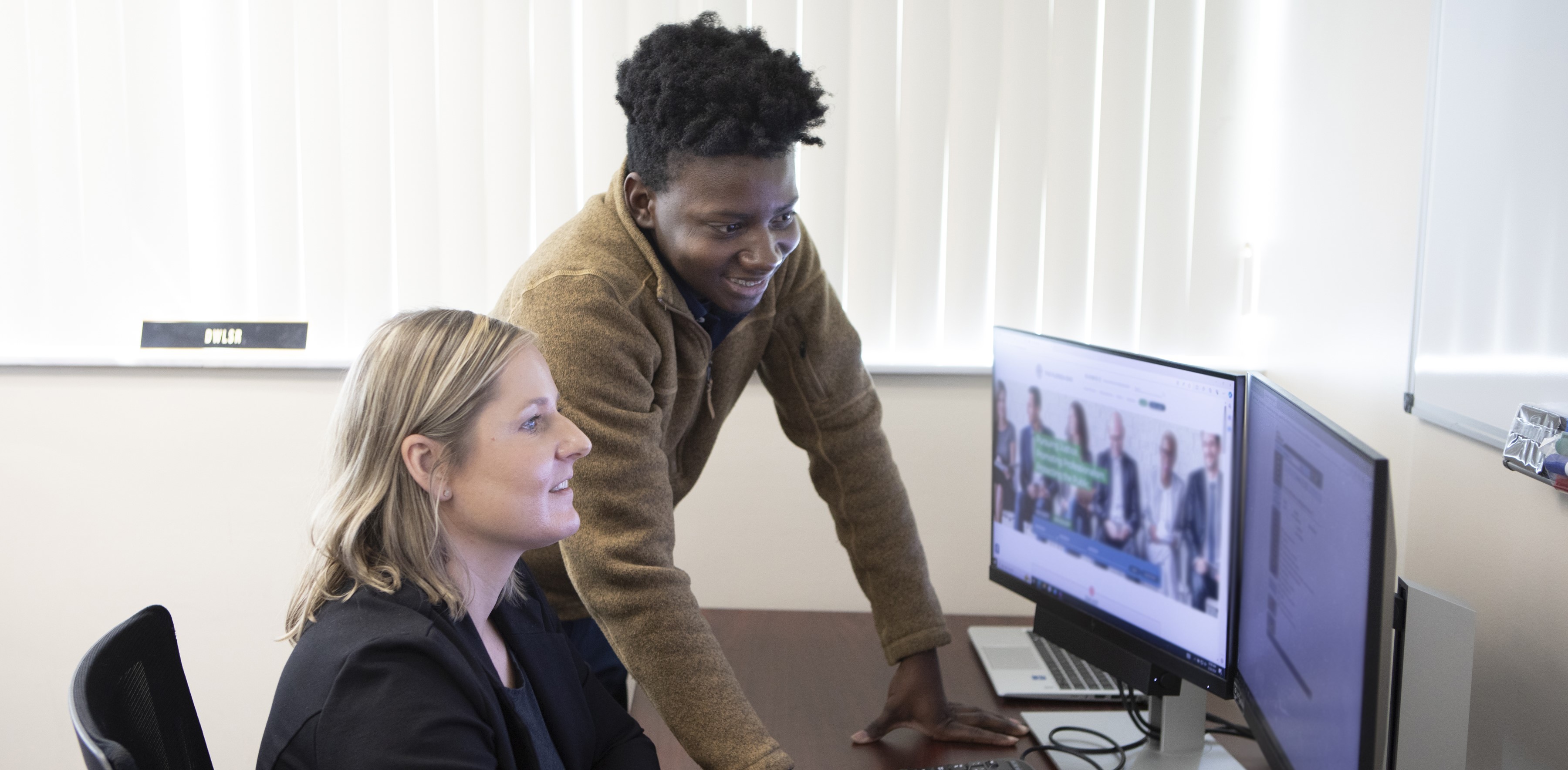 two students talking over a desk